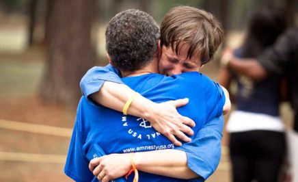Two people hug at a vigil in Jackson
