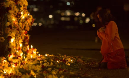 A person kneels in prayer at a #keephopealive vigil in Sydney to end the death penalty
