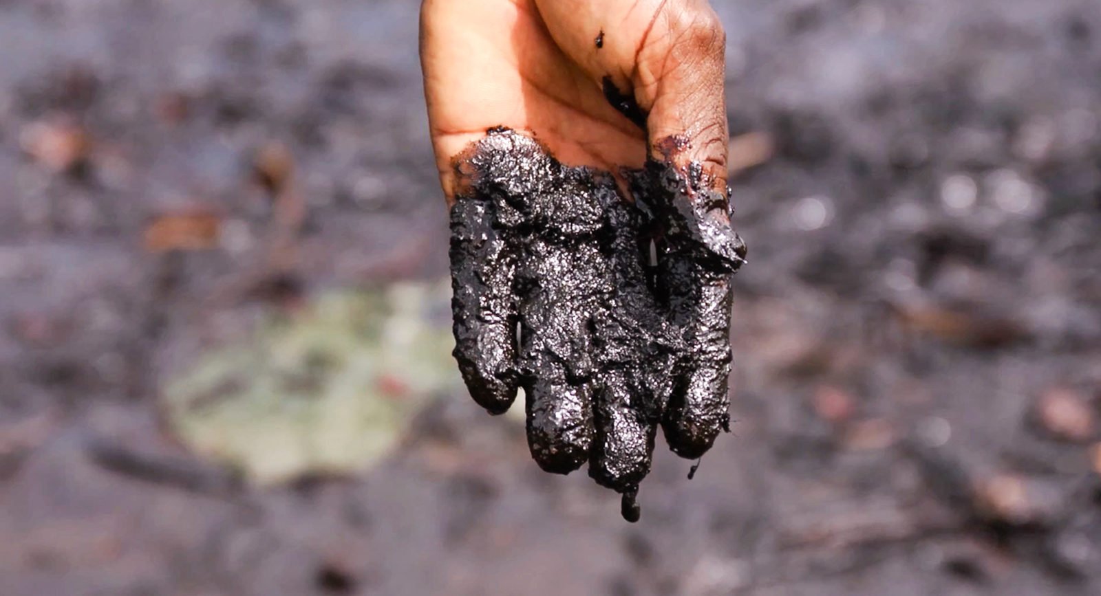 Pastor Christian Lekoya Kpandei's hand covered in oily mud, Bodo Creek, Nigeria, 2011