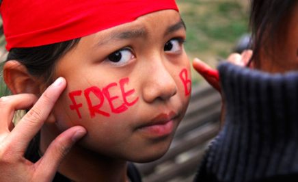 A young girl with 'Free Burma' written across her cheeks
