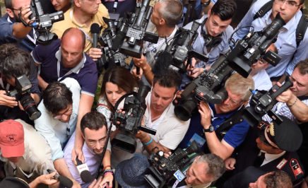 A large group of photographers and journalists at a press conference.