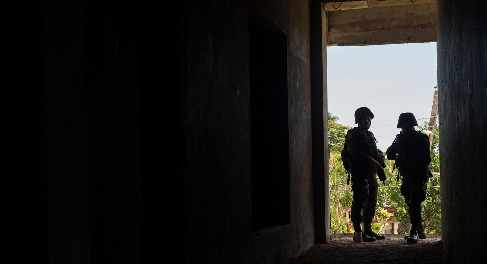 Members of the Philippine National Police silhouetted in a doorway