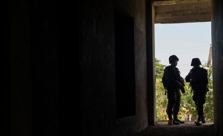 Members of the Philippine National Police silhouetted in a doorway