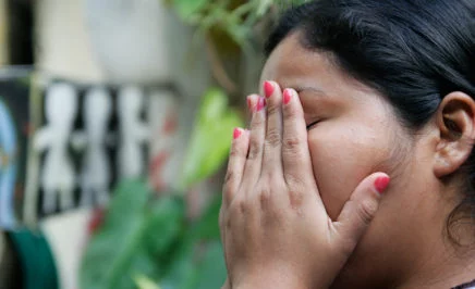 Woman with her hands over her face. Marlene, was accused and charged with having an abortion after she had a miscarriage when she was 18 years old.