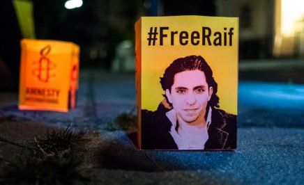 A small sign that reads '#FreeRaif' at a vigil outside the Saudi Arabian embassy in Vienna