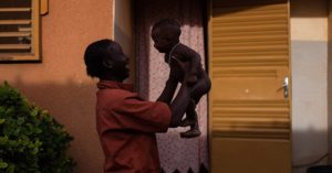 A woman plays with her child outside a shelter in Burkina Faso, which has the 7th highest rate of child marriage in the world.