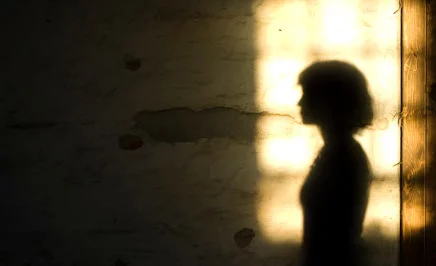 A woman's silhouetted shadow against a wall