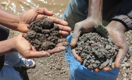 A close up photograph of Artisanal miners hold up handfuls of cobalt ore (left) and copper ore (right) in the Democratic Republic of the Congo in May 2015.