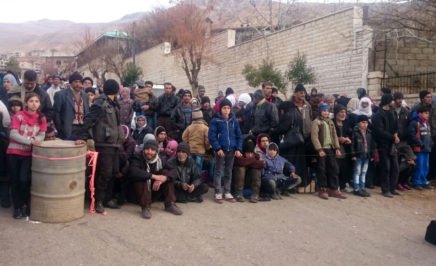 Syrians wait for the arrival of an aid convoy on January 11, 2016 in the besieged town of Madaya.