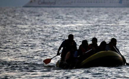 Migrants arrive on the shore of Kos island on a small dinghy.