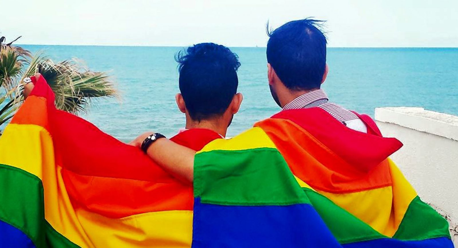 Two people wearing rainbow flags in Tunisia