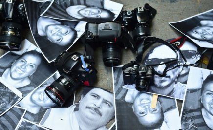 Photos of killed journalists with cameras at a protest for press freedom in Mexico City