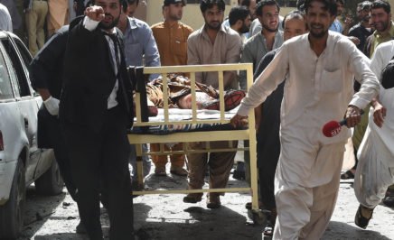 Pakistani lawyers and local media personnel carry a bed to move the body of a news cameraman after a bomb explosion at a government hospital in Quetta.