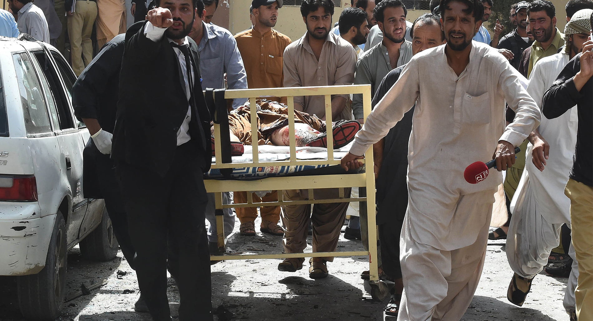 Pakistani lawyers and local media personnel carry a bed to move the body of a news cameraman after a bomb explosion at a government hospital in Quetta.