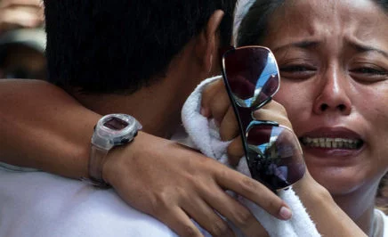 Relatives of Michael Siaron grieve during his burial ceremony at a cemetery in Manila.