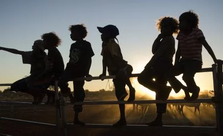 Silhouette of children on a fence