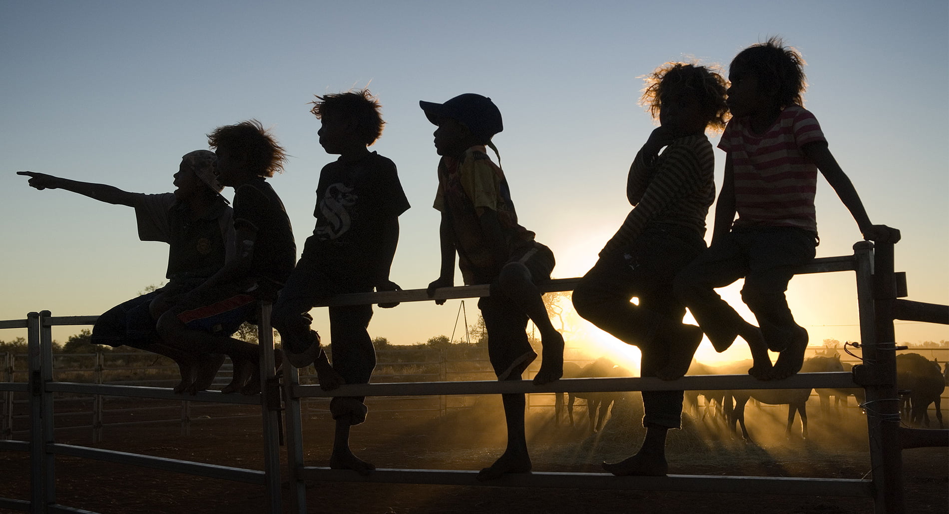 Silhouette of children on a fence