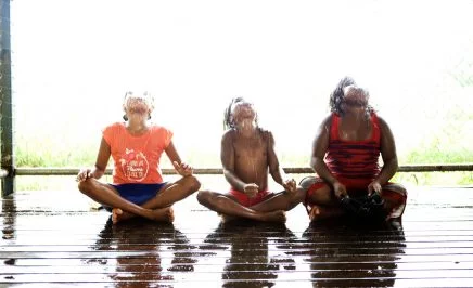 Three Indigenous children playing in water