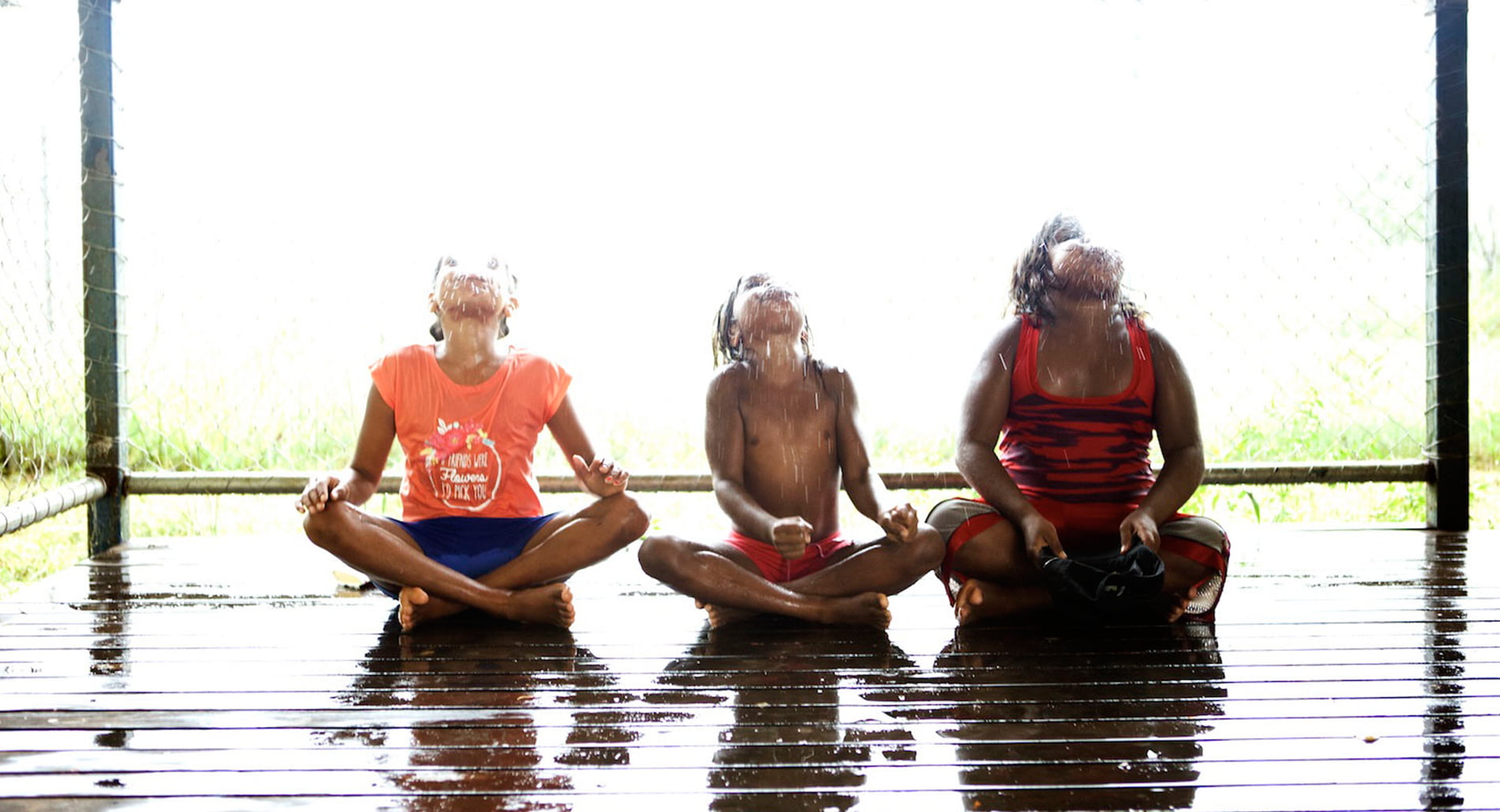 Three Indigenous children playing in water