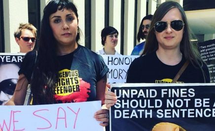 Two women holding signs stating 