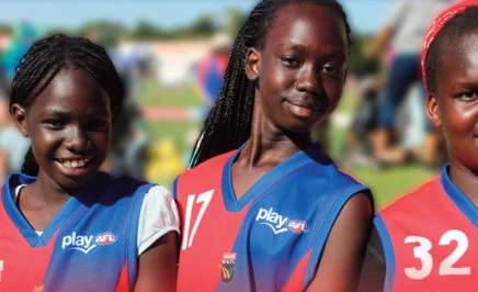 Gilrs smiling to the camera for refugee week