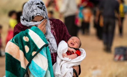 A young mother fleeing Syria with her baby