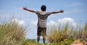 Indigenous man throws his hands wide