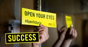 Hand holding "Open your Eyes" sign
