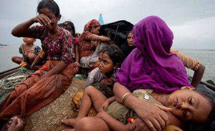 Group of Rohingya refugee women and children on boat at sea