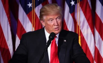 Donald Trump standing in front of an American flag