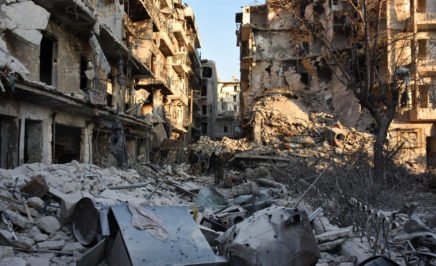 Syrian pro-government forces walk amidst heavy destruction in Aleppo's Bustan al-Basha neighbourhood