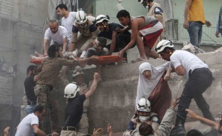 Syrian rescue workers and citizens evacuate people from a building following a reported barrel bomb attack by Syrian government forces.