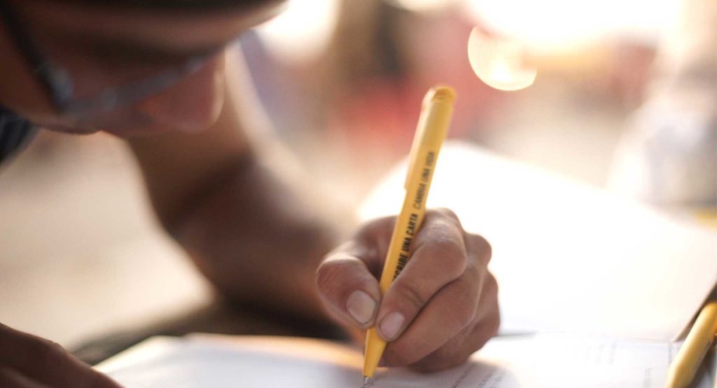 A person writing a letter