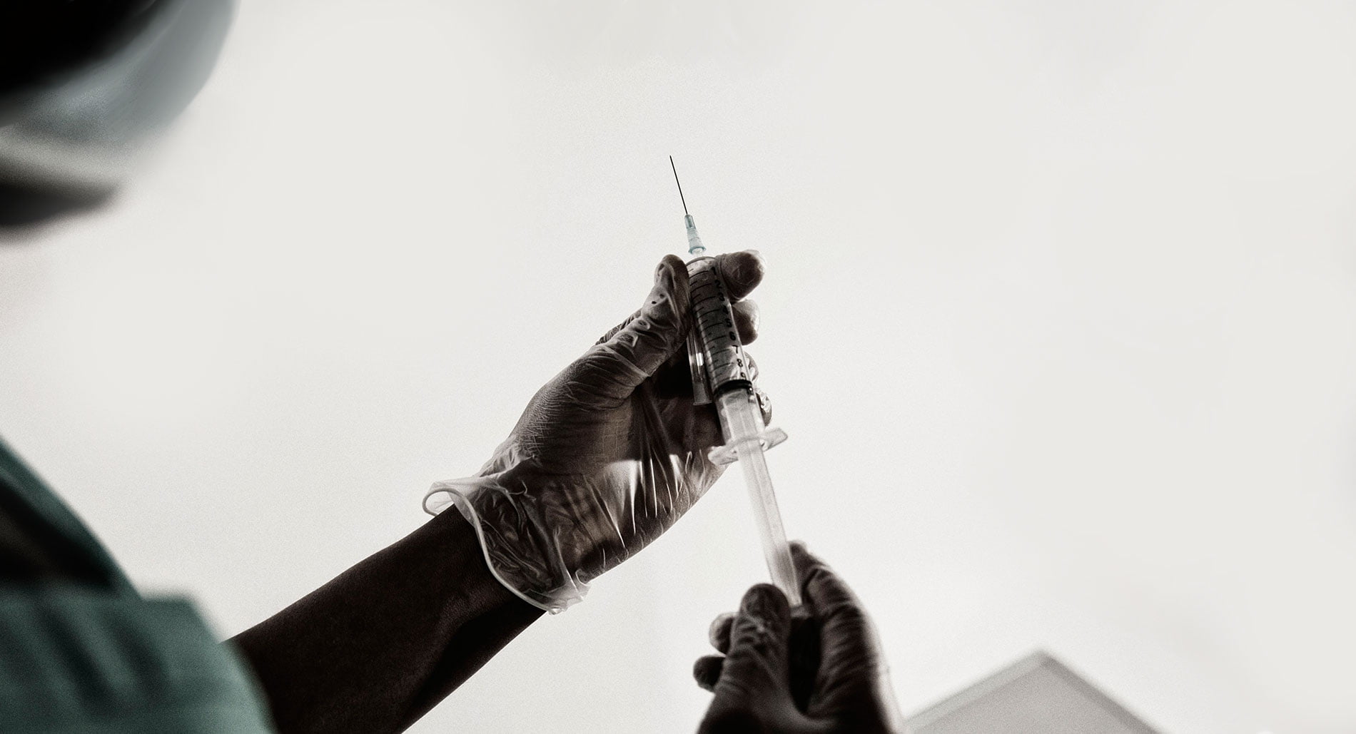 A gloved hand holding a syringe. &copy; Amnesty International
