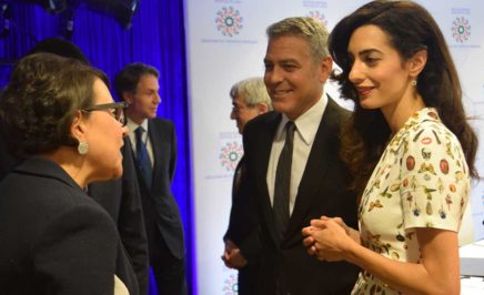 George Clooney and others in a group talking in front of a camera