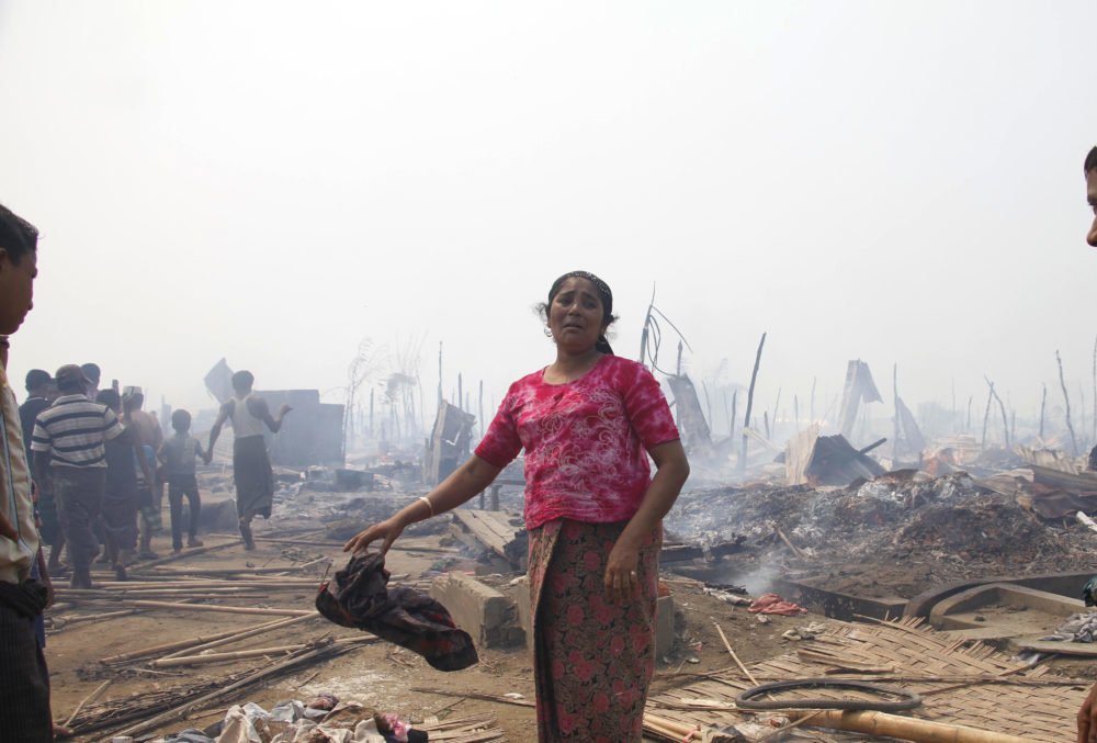 A Rohingya woman grieves after a fire gutted her family's shelter, Rakhine state, May 2016