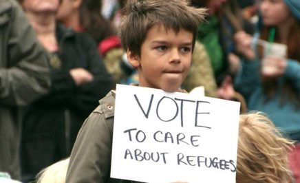 Child refugee holding up a sign at a protest in Melbourne