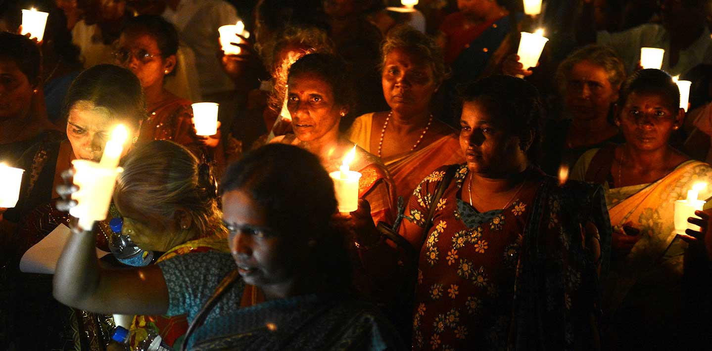 Sri Lankan activists hold lighted candles during a candlelight vigil in Colombo