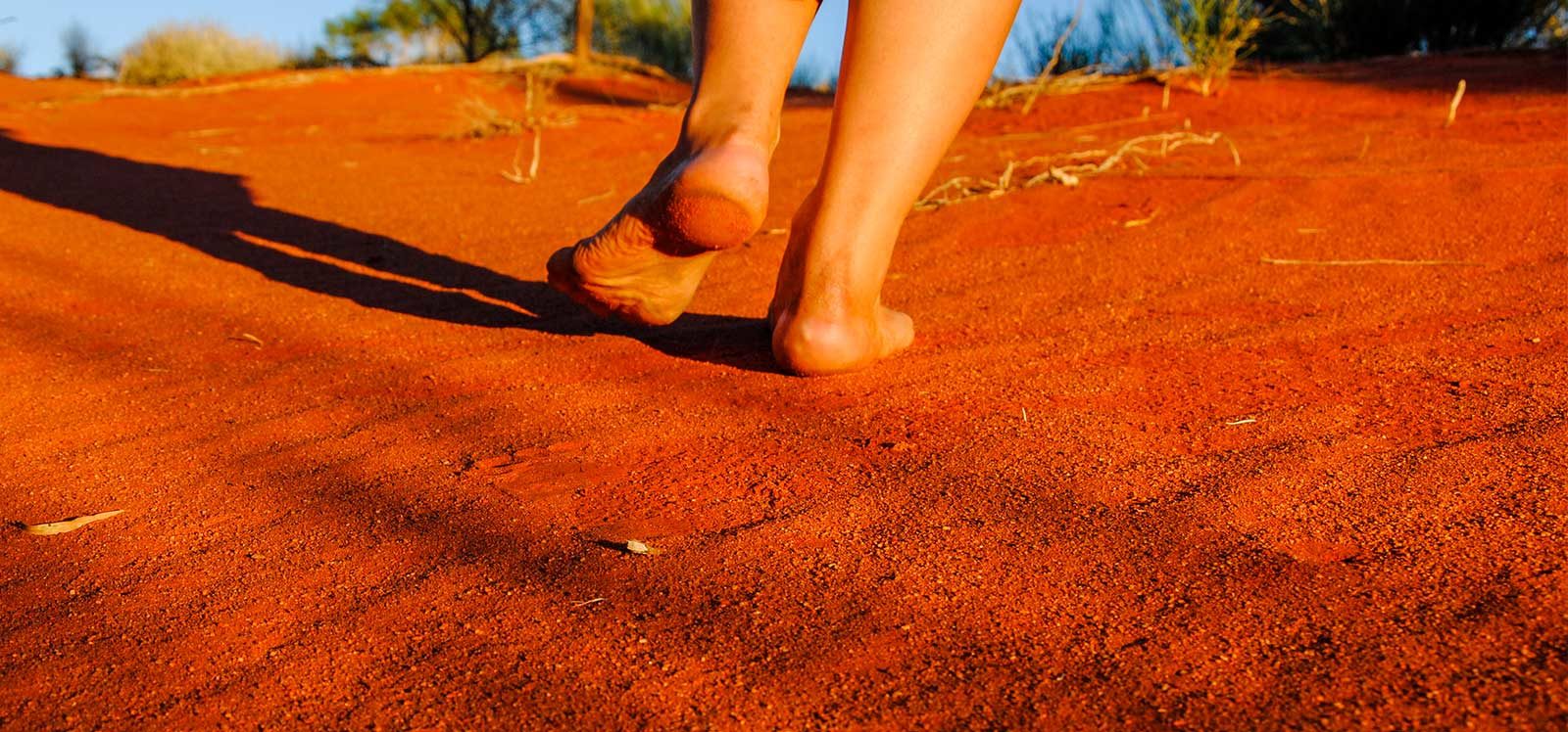 Walking barefoot on red sand dune