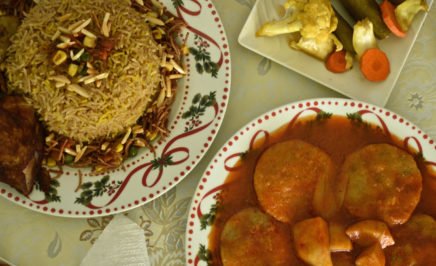 A plate of Biryani with side dishes of vegetables