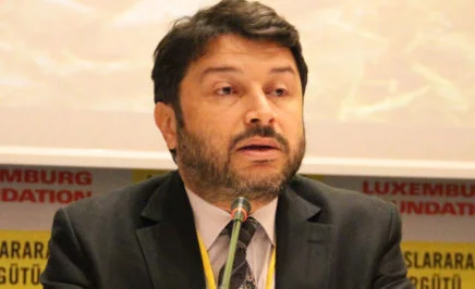 A close up photo of Taner Kiliç speaking into a microphone
