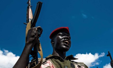 A Sudan People's Liberation Army (SPLA) soldier holds up a gun