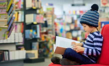 A young boy reading in a library. © iStock/tatyana_tomsickova