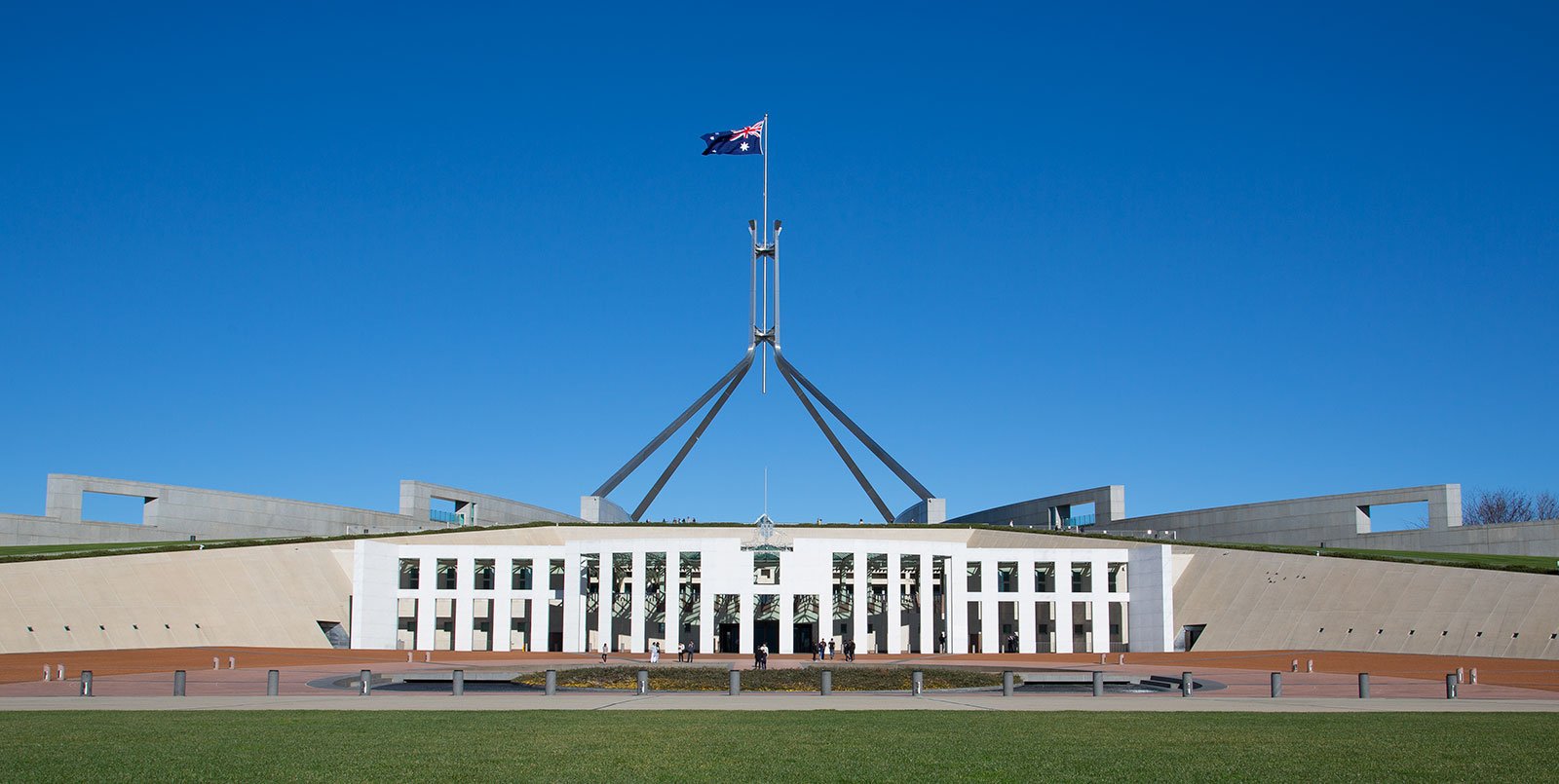 A photo of Parliament House in Canberra, set against a deep blue sky