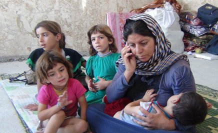 A photo a woman and her children at an IDP camp in Northern Iraw. Sawsan Hassan is trying to contact her husband, who was abducted by IS on 3 August 2014, by mobile phone.