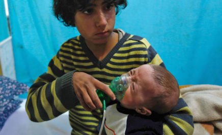 A Syrian boy holds an oxygen mask over the face of an infant at a make-shift hospital following a reported gas attack in Eastern Ghouta.