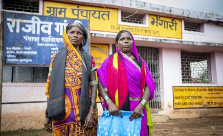 Pavitri Manjhi, a Human Rights Defender from Chattisgarh, India stands with another women in front of a shop.