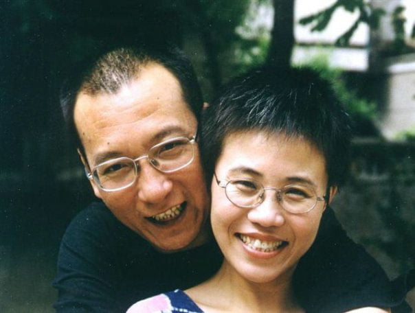 Chinese artist Liu Xia with her late husband and Nobel laureate in 2001. Both are smiling and have their arms around each other.