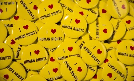 Hundreds of yellow badges with 'I heart human rights' printed on them.