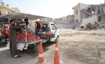 Farmers in Syria unloading vegetables from a flatbed truck.